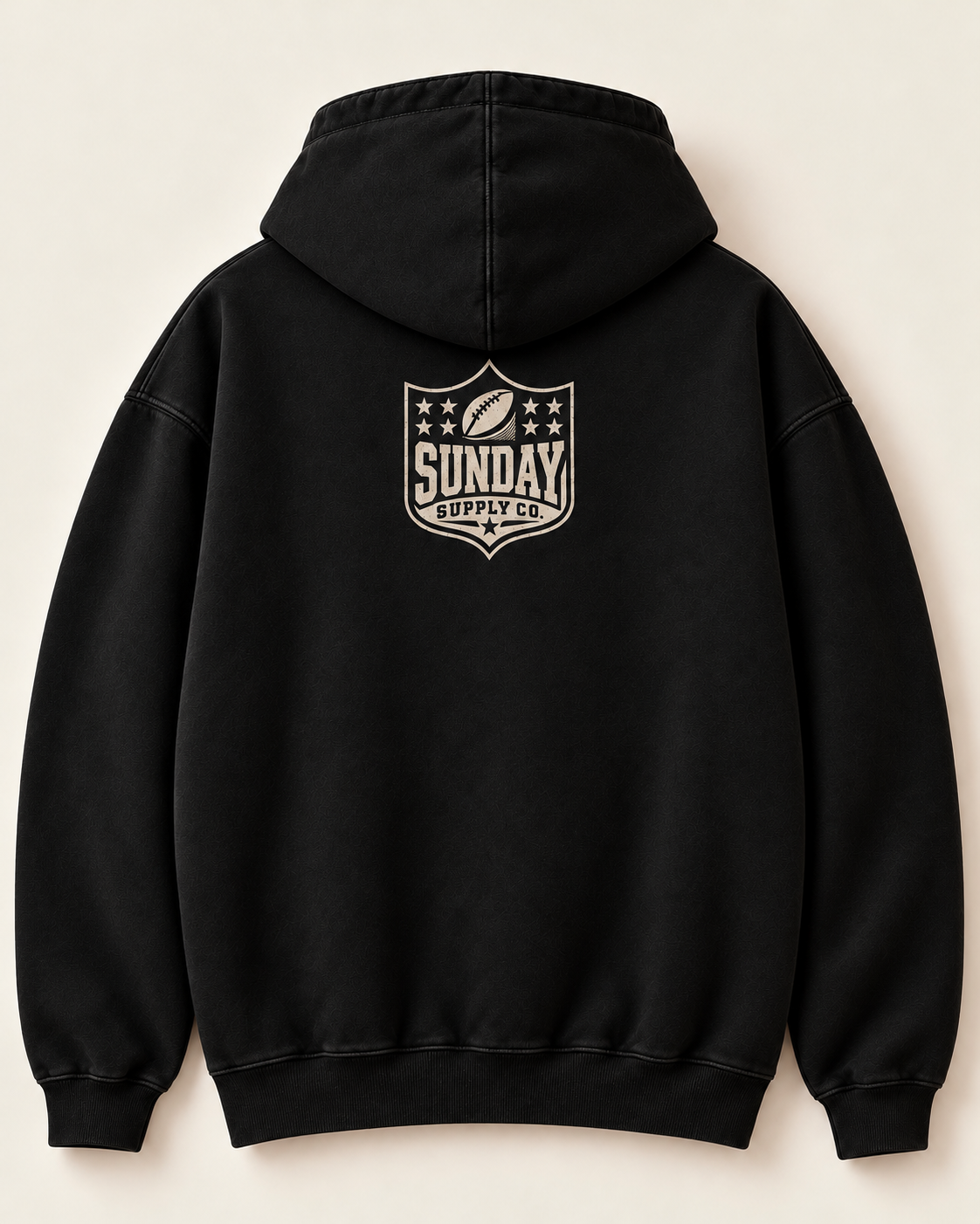 Solid black French terry hoodie back with monochrome cream Sunday Supply crest